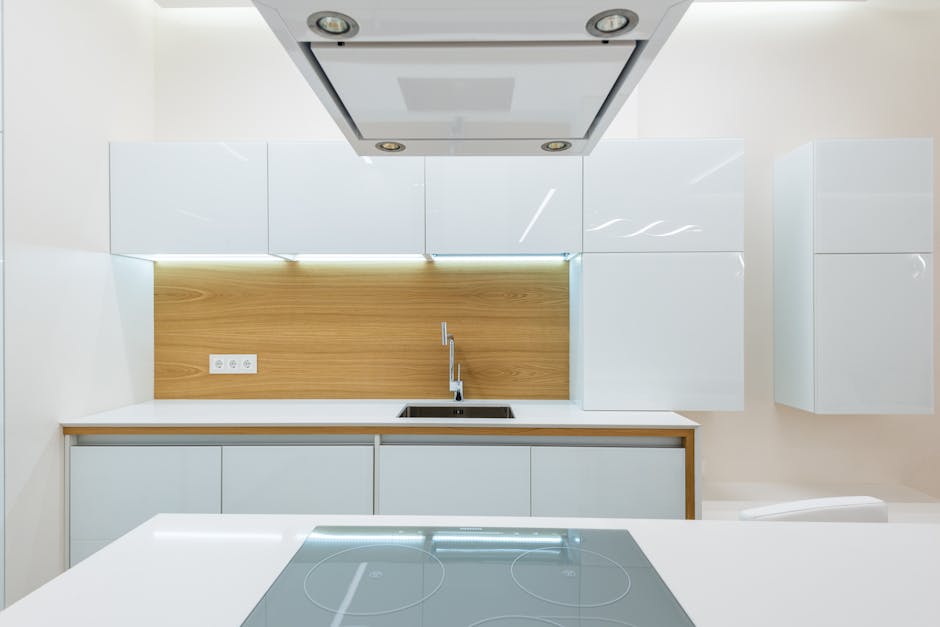 Interior of new empty kitchen with white furniture with wooden elements in modern apartment